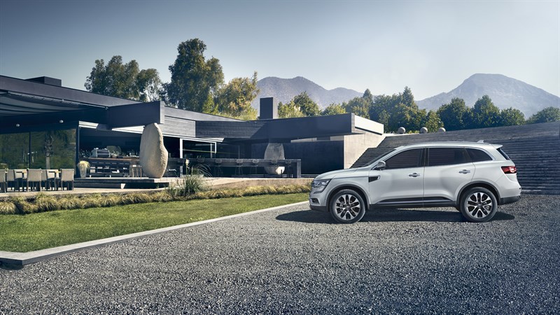 Renault KOLEOS - Vue de profil du véhicule devant une maison